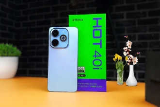 The Infinix Hot 40i smartphone displayed against a colorful gradient background, showing its side-mounted fingerprint sensor and glossy back panel.