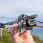 DJI Mini 5 Pro drone in dark grey, folded compactly with propellers secured for travel.