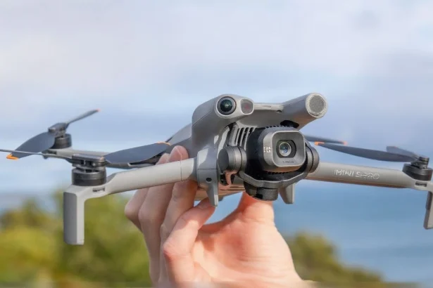 DJI Mini 5 Pro drone in dark grey, folded compactly with propellers secured for travel.