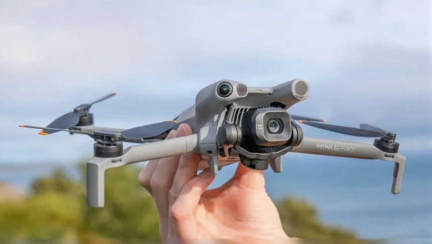 DJI Mini 5 Pro drone in dark grey, folded compactly with propellers secured for travel.
